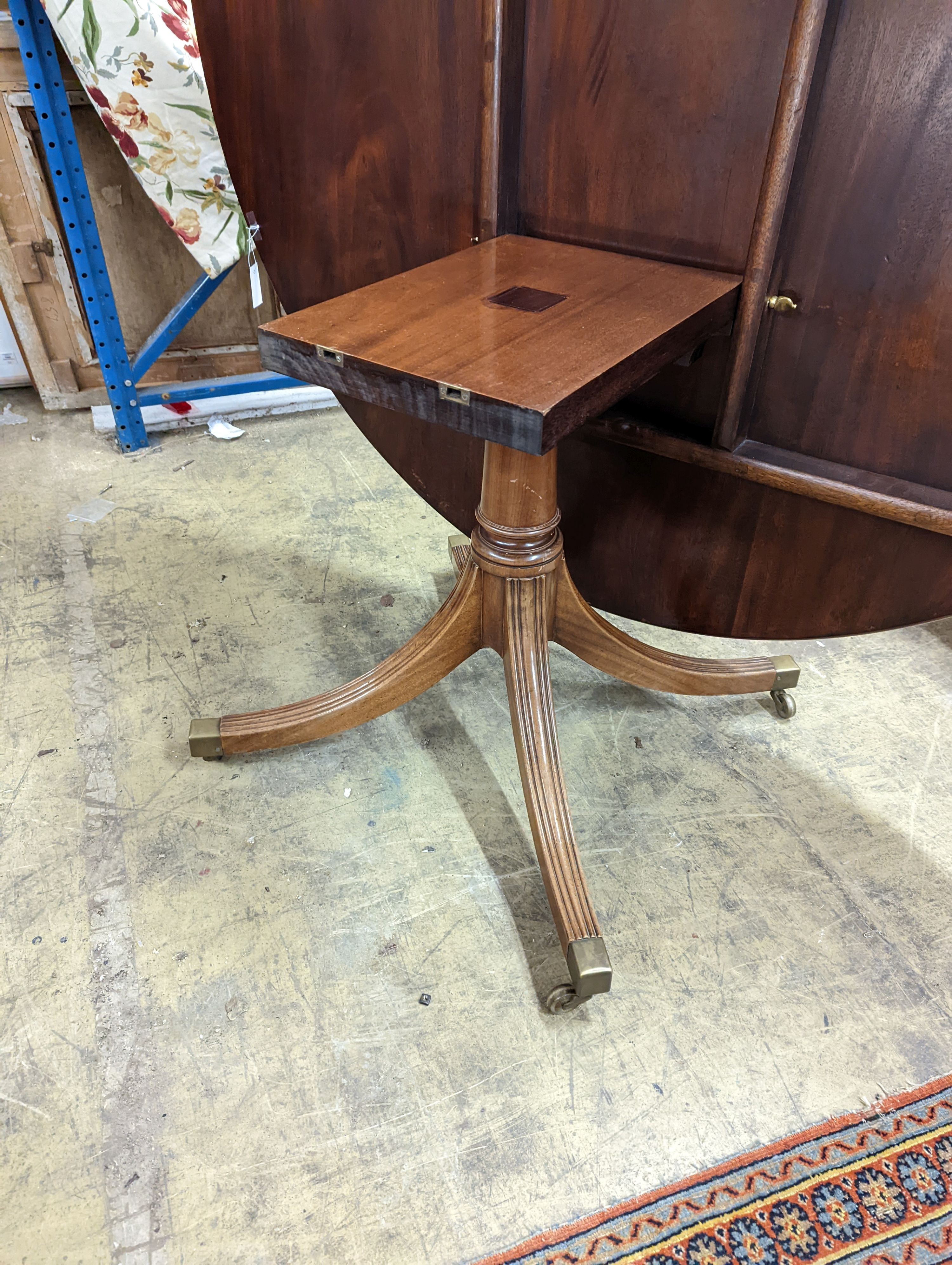 Attributed to William Tillman, a reproduction George III style banded mahogany circular pedestal tilt top dining table, diameter 160cm, height 72cm